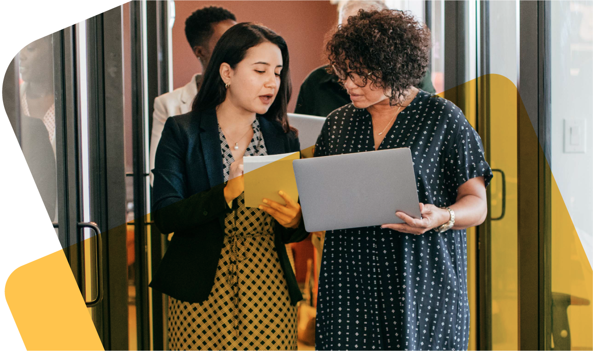 Two women standing and collaborating at laptop